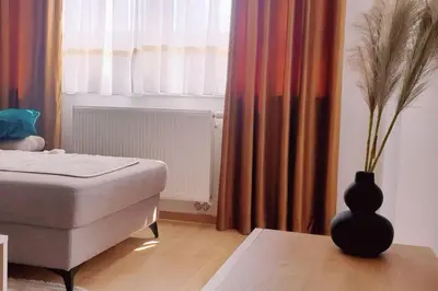 a bedroom with a bed and a vase on a table at R-RESIDENCY Panorama in Banja Luka
