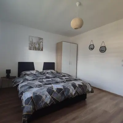 a bedroom with a bed and a white wall at Apartman Čolić - Kupres in Kupres