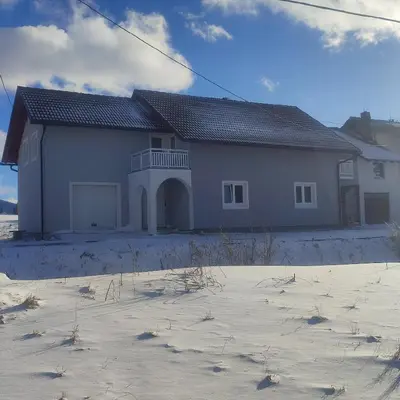 a large white house in the snow at Apartman Čolić - Kupres in Kupres