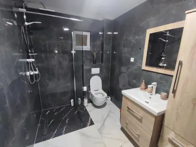 a bathroom with a shower and a toilet and a sink at Apartman Čolić - Kupres in Kupres