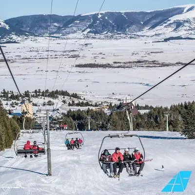 a group of people riding a ski lift in the snow at Apartman Svalina in Kupres