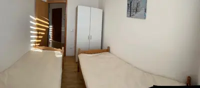 two beds in a room with white walls at Apartman Svalina in Kupres
