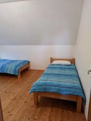 a bedroom with two beds and a wooden floor at Vila Ružica in Kupres