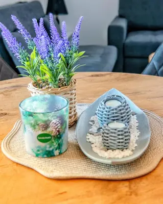 a table with a plate and a candle and plants at Vikendica Jadranka in Kupres