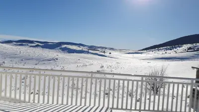 a white fence in front of a snow covered slope at Vikendica Jadranka in Kupres