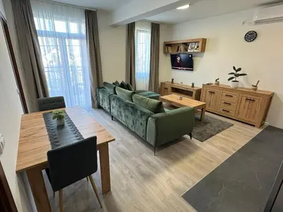a living room with a green couch and a table at S Apart Rooms in Bosanska Gradiška