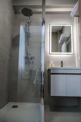 a bathroom with a shower and a sink and a mirror at S Apart Rooms in Bosanska Gradiška