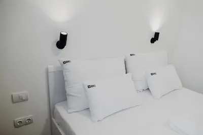 two beds with white pillows in a room at S Apart Rooms in Bosanska Gradiška