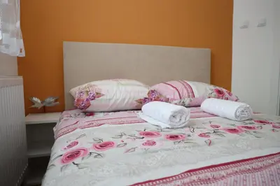 a bed with pink and white sheets and pillows at Apartman Solunska 18 Banja Luka in Banja Luka
