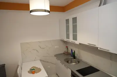 a white kitchen with a sink and a counter at Apartman Solunska 18 Banja Luka in Banja Luka