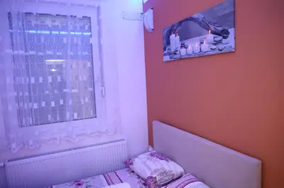a bedroom with a bed and a window with a picture at Apartman Solunska 18 Banja Luka in Banja Luka