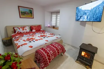 a bedroom with a bed and a fireplace and a television at Guest House Lejla in Travnik