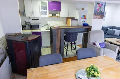 a kitchen and living room with a table and chairs at Guest House Lejla in Travnik