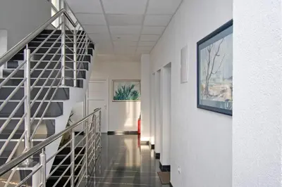 a hallway with stairs and paintings on the walls at Apartmani Sebastijan in Banja Luka
