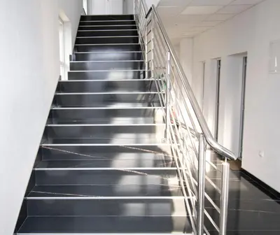 a staircase in an office building with black stairs at Apartmani Sebastijan in Banja Luka