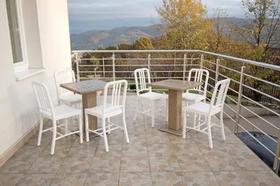 a patio with tables and chairs on a balcony at Apartmani Sebastijan in Banja Luka