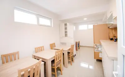 a kitchen and dining room with wooden tables and chairs at Apartmani Sebastijan in Banja Luka