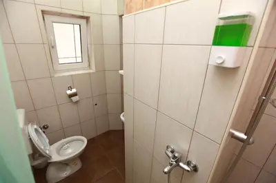 a small bathroom with a toilet and a window at Hostel Cuba in Banja Luka