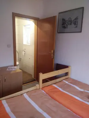 a bedroom with a bed and a bathroom with a mirror at Hostel Cuba in Banja Luka