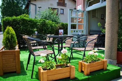 a patio with chairs and tables and potted plants at Hostel Cuba in Banja Luka