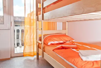 a bedroom with two bunk beds and a balcony at Hostel Cuba in Banja Luka