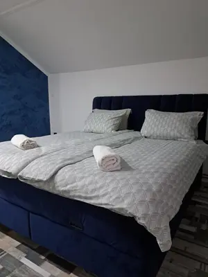 a blue bed with two towels on top of it at Apartman Mihaela in Laktaši