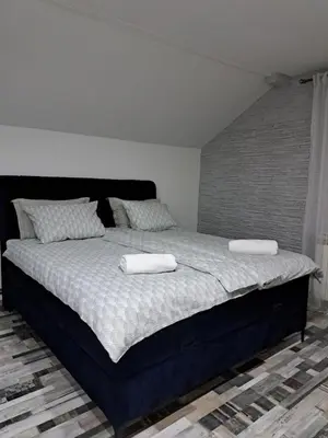 a bedroom with a large bed with two towels on it at Apartman Mihaela in Laktaši
