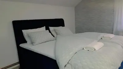 a bedroom with two beds with white sheets and pillows at Apartman Mihaela in Laktaši