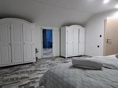 a white bedroom with a large bed and a window at Apartman Mihaela in Laktaši