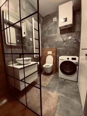 a bathroom with a toilet a sink and a washing machine at Apartman Stojić in Banja Luka