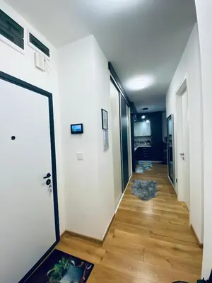 a hallway with a white door and a wooden floor at Apartman Stojić in Banja Luka