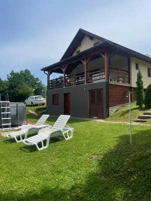 a group of white lawn chairs in front of a building at Vikendica Krupa in Banja Luka