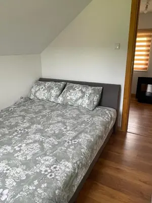 a bedroom with a bed with a gray comforter at Vikendica Krupa in Banja Luka