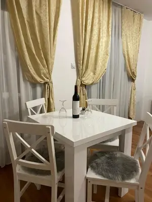 a white table with two chairs and a bottle of wine at Vikendica Krupa in Banja Luka