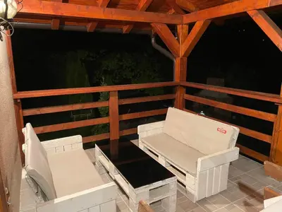 two white chairs on a porch with a wooden roof at Vikendica Krupa in Banja Luka