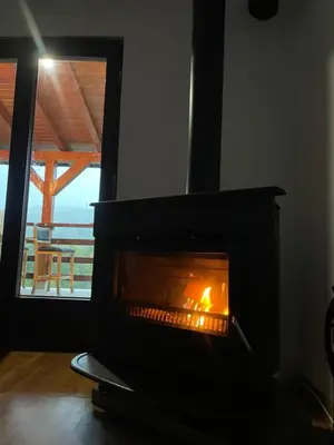 a fireplace in a room with a view of the ocean at Vikendica Krupa in Banja Luka