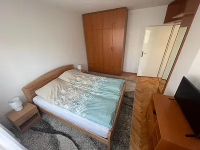 a small bedroom with a bed and a cabinet at Apartman IN in Banja Luka