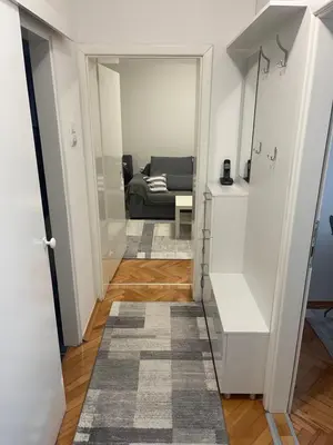 a hallway with a living room with a couch at Apartman IN in Banja Luka
