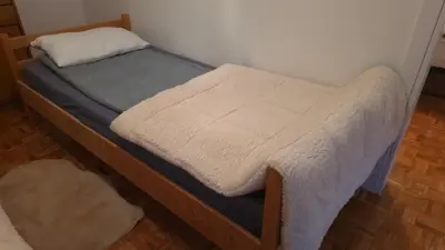 a small bed in a room with a white blanket at Evergreen in Banja Luka