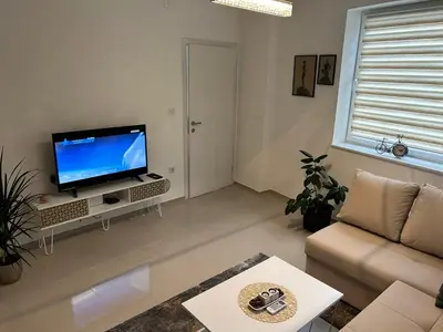 a living room with a television and a couch at Apartman Magus in Tuzla