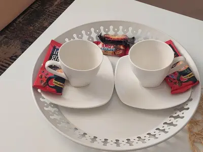 two cups on a plate with snacks on a table at Apartman Magus in Tuzla