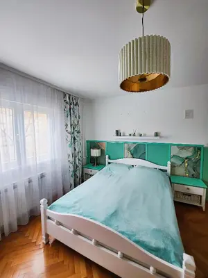 a bedroom with a bed and a chandelier at Apartman TaMaRa in Doboj