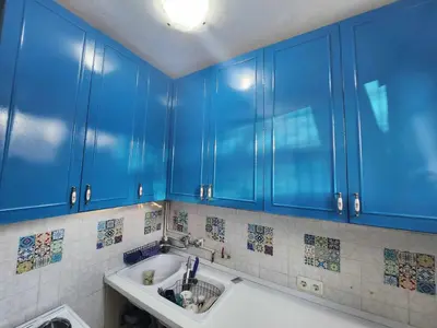 a kitchen with blue cabinets and a sink at Apartman TaMaRa in Doboj
