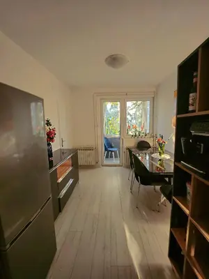 a kitchen with a table and a refrigerator in a room at Apartman TaMaRa in Doboj