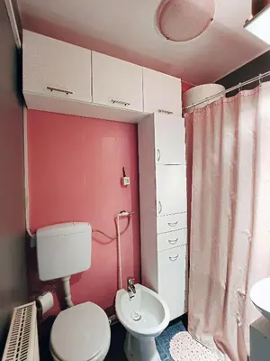 a pink bathroom with a toilet and a sink at Apartman TaMaRa in Doboj
