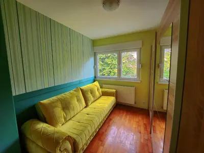 a living room with a couch and two windows at Apartman TaMaRa in Doboj