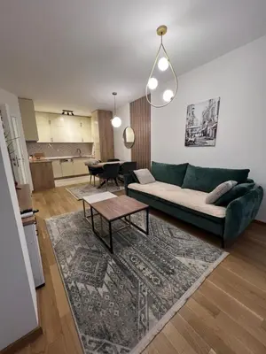 a living room with a green couch and a table at Romanijska in Banja Luka