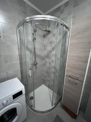 a shower in a bathroom with a washing machine at Romanijska in Banja Luka