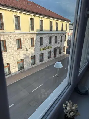 a window with a view of a building and a street at Rosa Canina Kupres 2 - Centar in Kupres