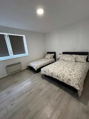 two beds in a bedroom with wooden floors at Rosa Canina Kupres 2 - Centar in Kupres